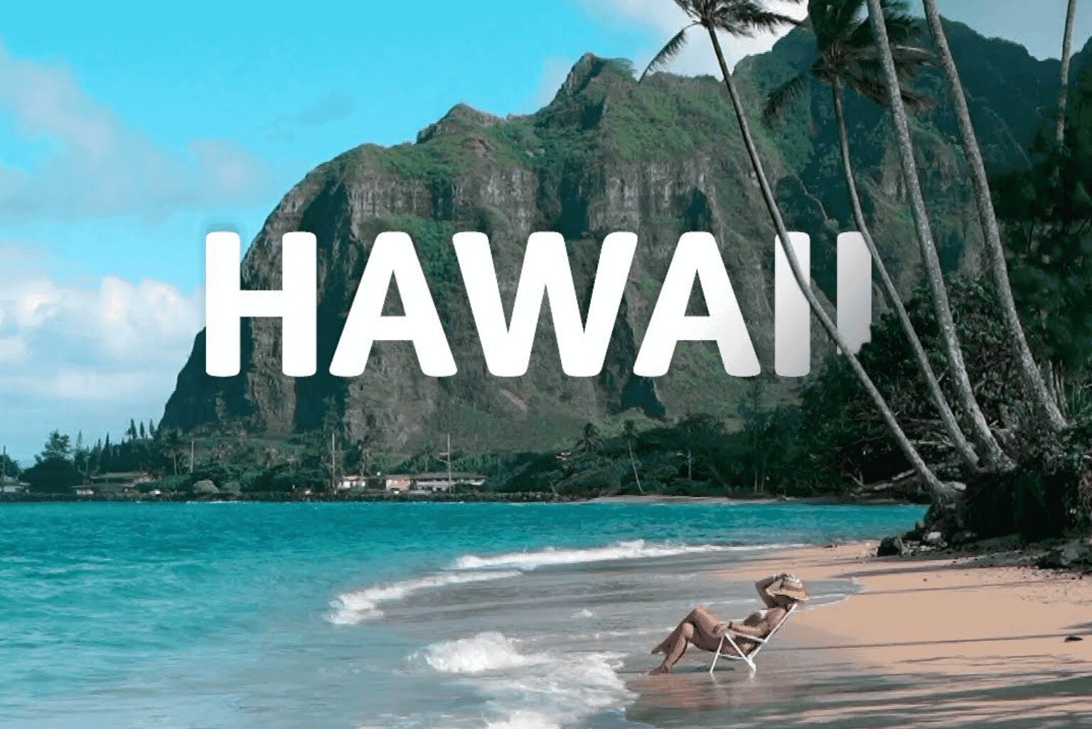 Tropical beach scene in Hawaii with palm trees and mountain backdrop.