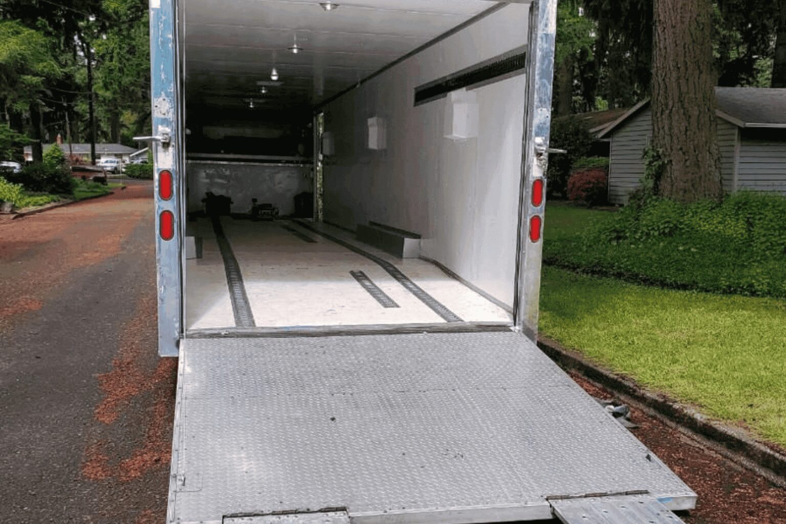 Empty enclosed trailer with loading ramp lowered.