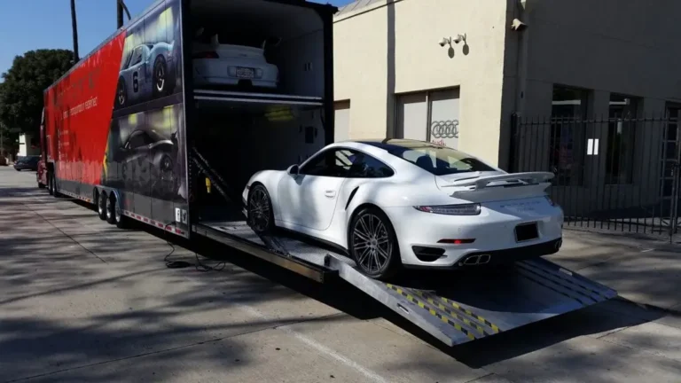 White sports car being loaded onto trailer.